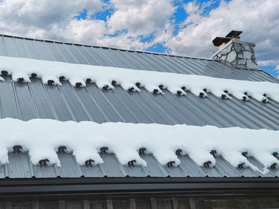 Multiple rows of Kodiak SnowCatcher snow guards on a roof holding snow