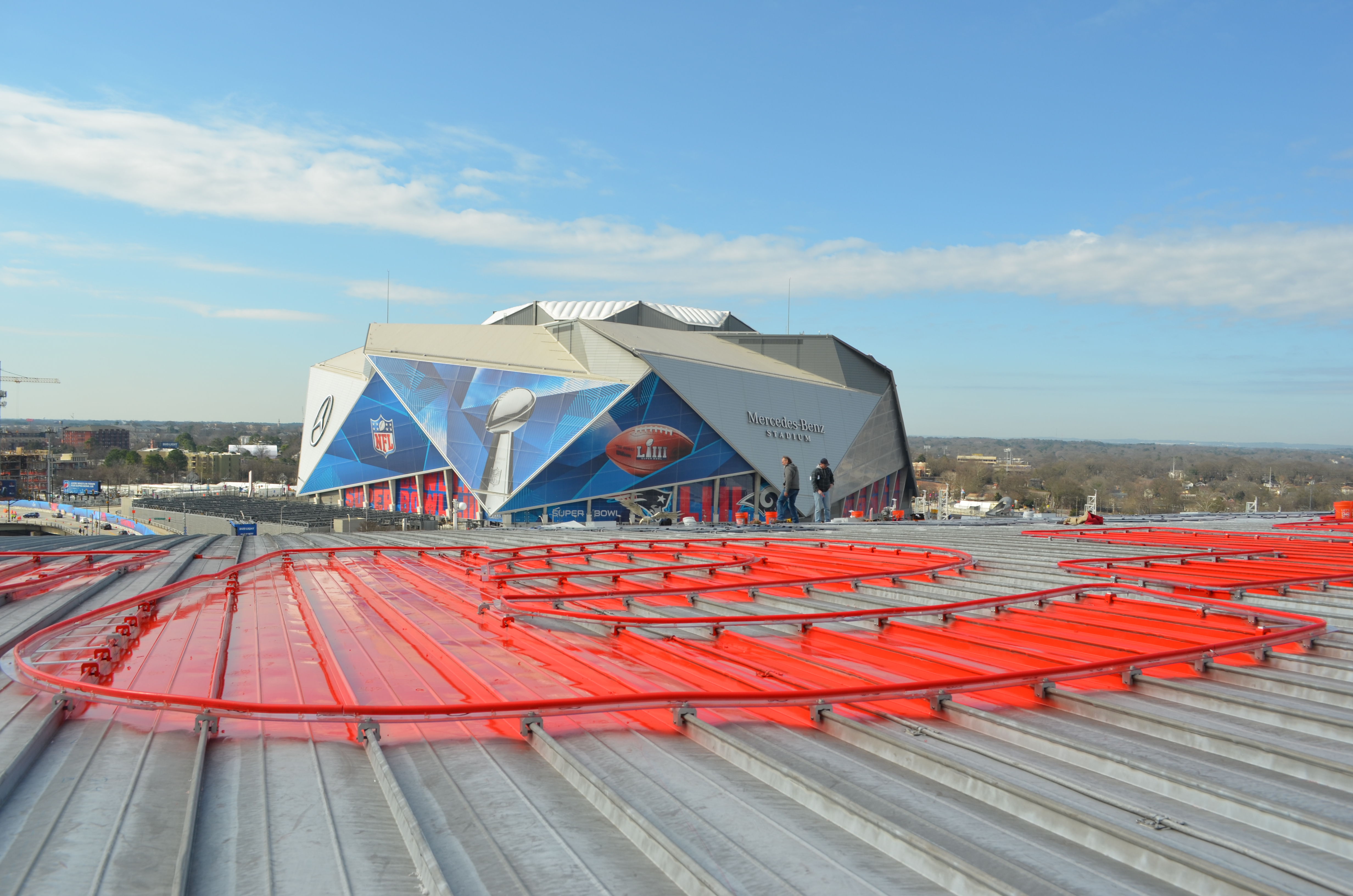 Neon lighting being installed on state farm arena in Atlanta with RoofClamp RCT