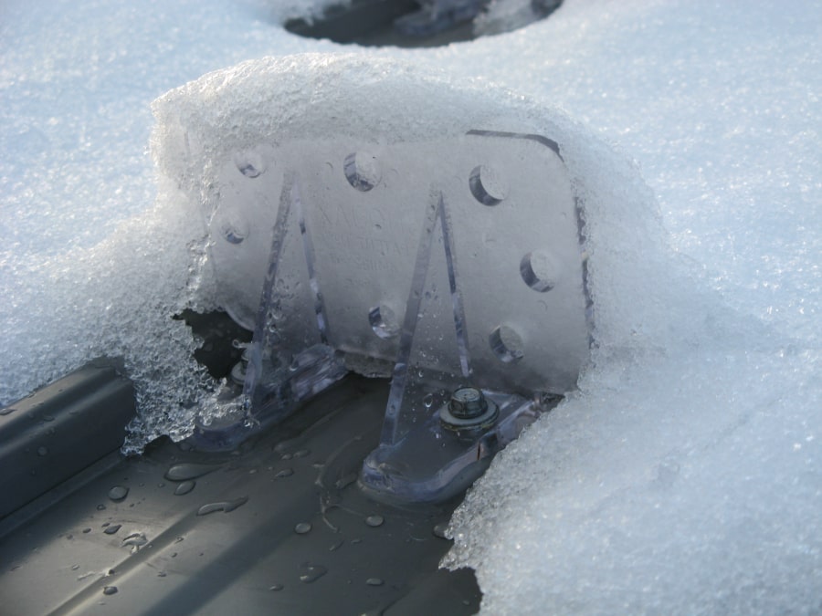 Image of a Snojax 1 snow guard mounted on a metal roof holding snow.