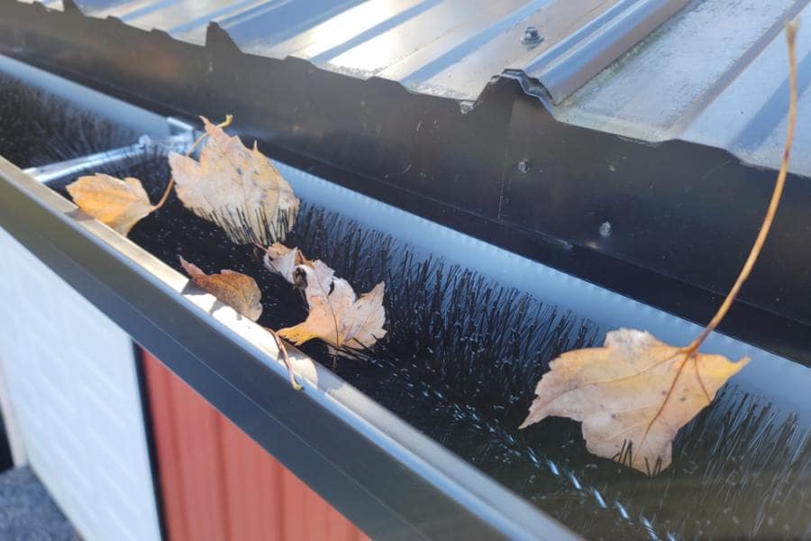 LeafBlox installed on red garage with leaves that will blow out in high winds