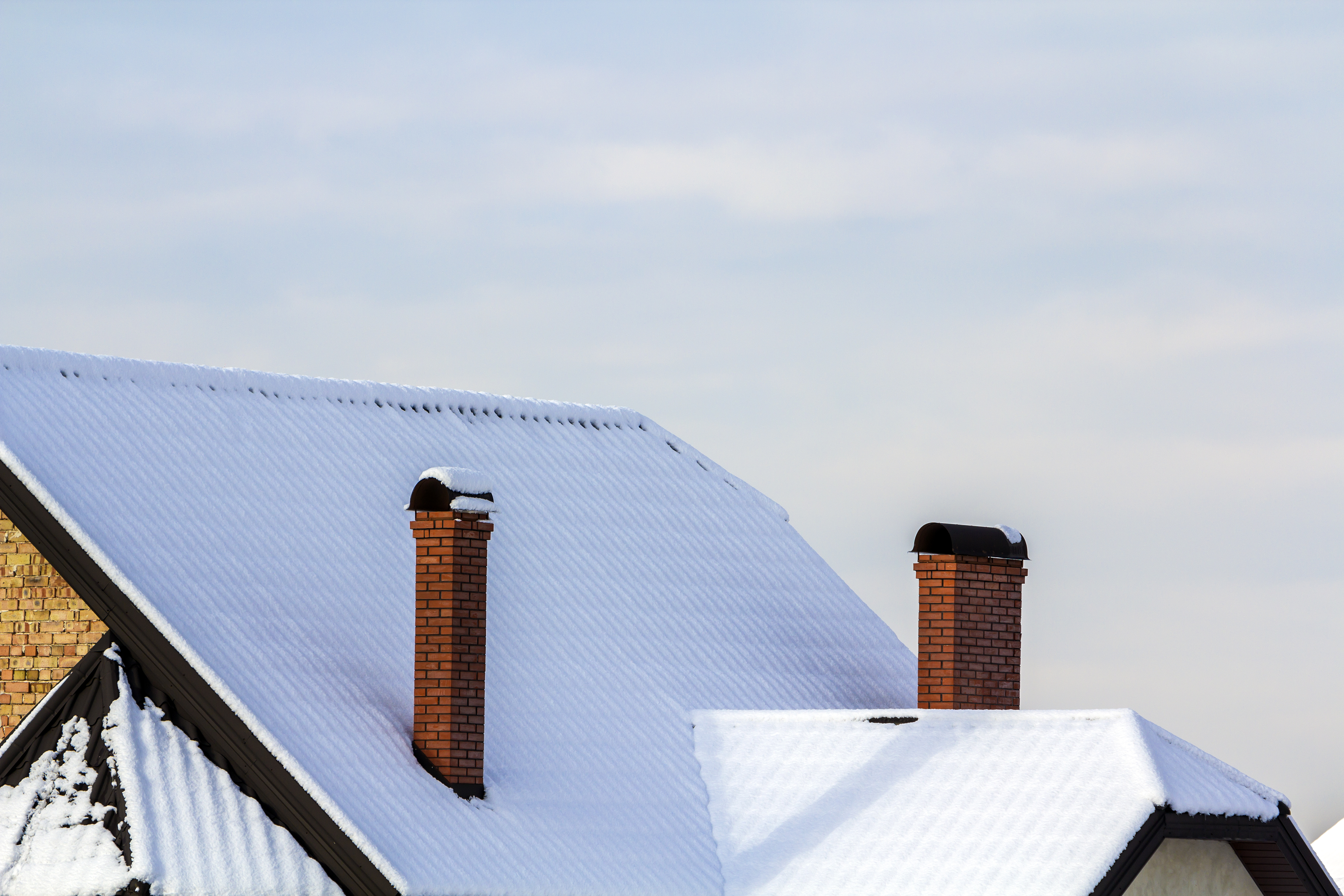 Image showing a light amount of snow covering a roof and chimneys