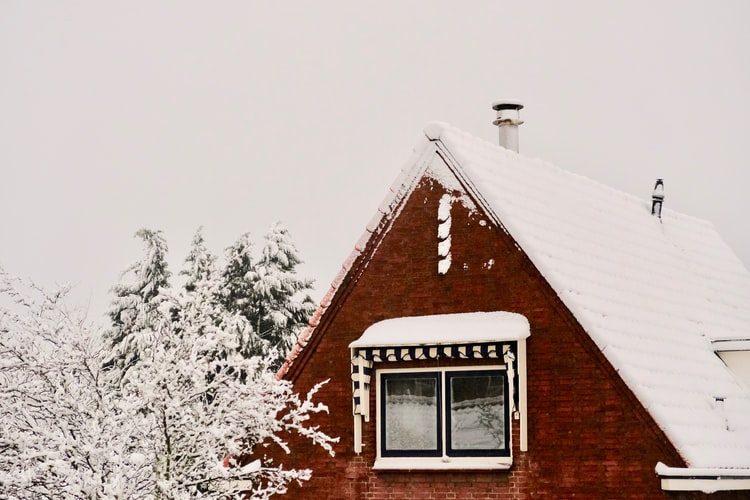 Snow on a brick building roof 