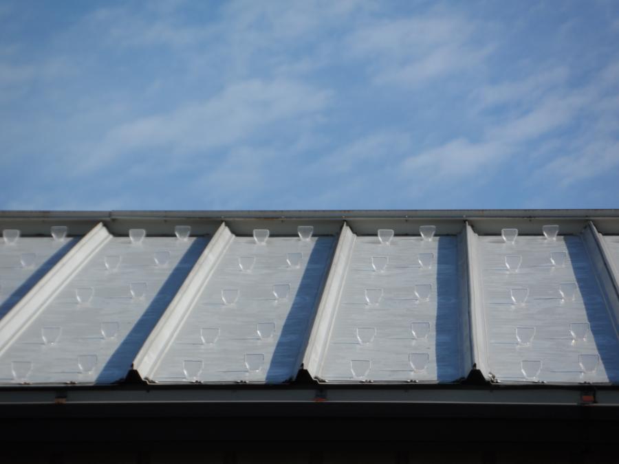 Multiple rows of clear SnoBlox Deuce mounted in proper layout configuration on galvanized standing seam roof panel. 