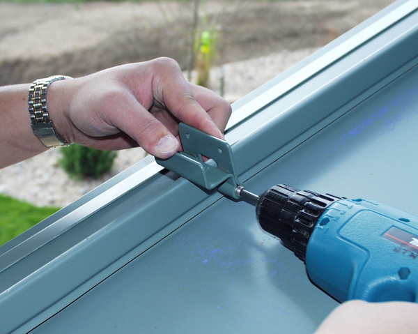 Image showing SnoBar clamps being installed on standing seam metal roof