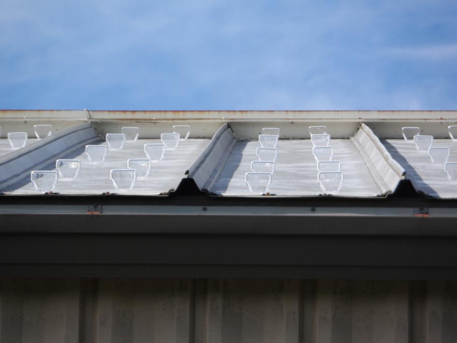 Multiple rows of adhesive mounted SnoBlox Deuce on Silver Ultra-Dek Roofing