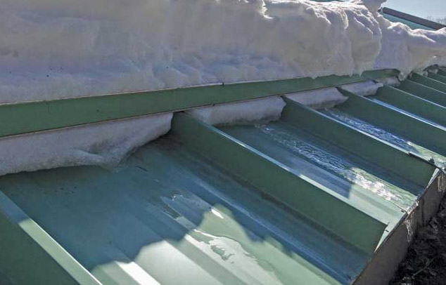 Image shows snow rail holding heavy snow load on roof