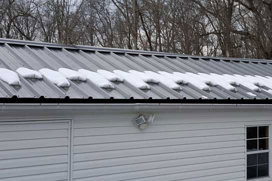 Snow Guards holding snow on a screw down metal roof